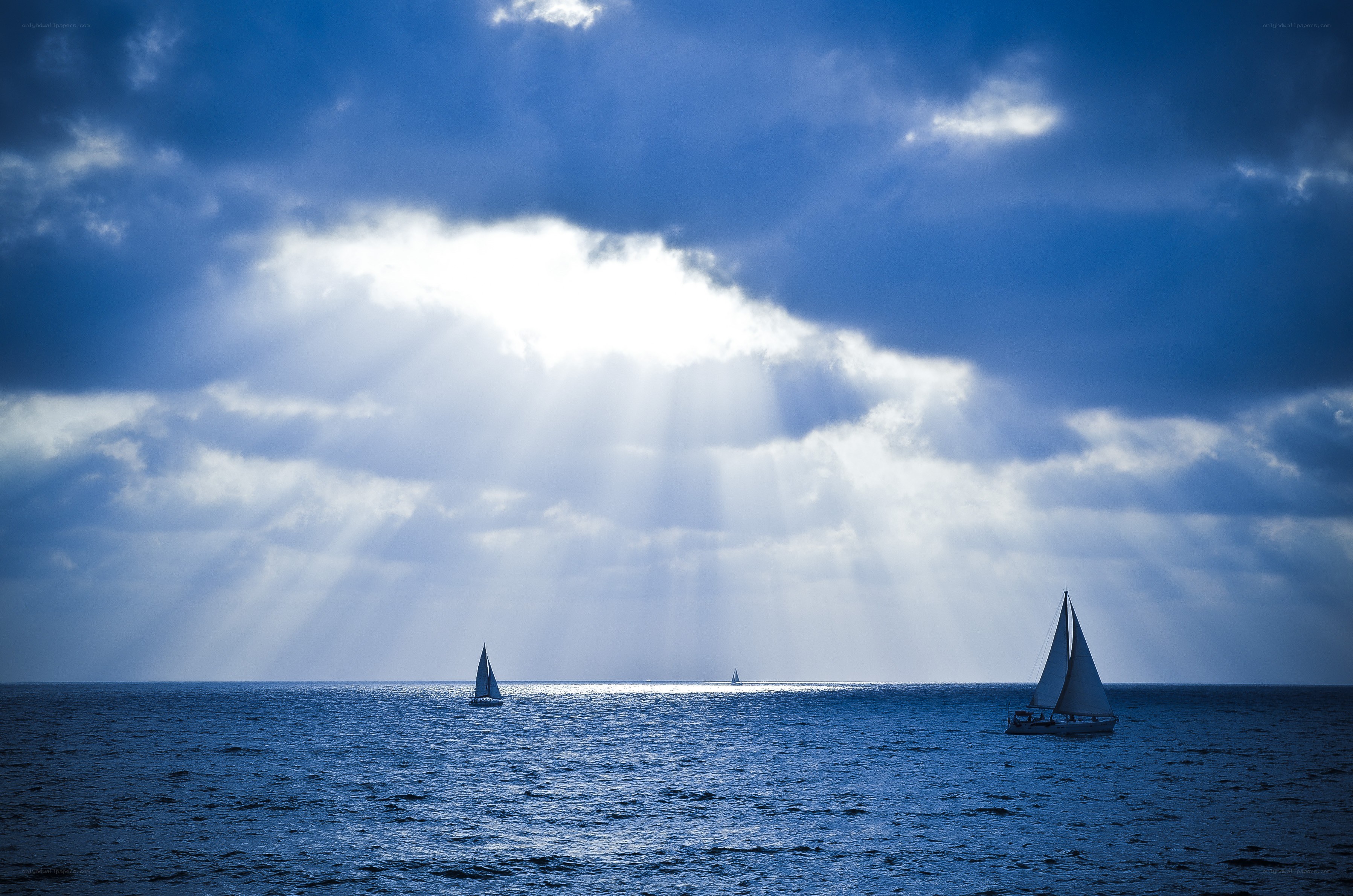 Sailboats under sunbeams