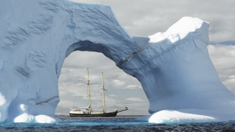 Sailing under an iceberg arch