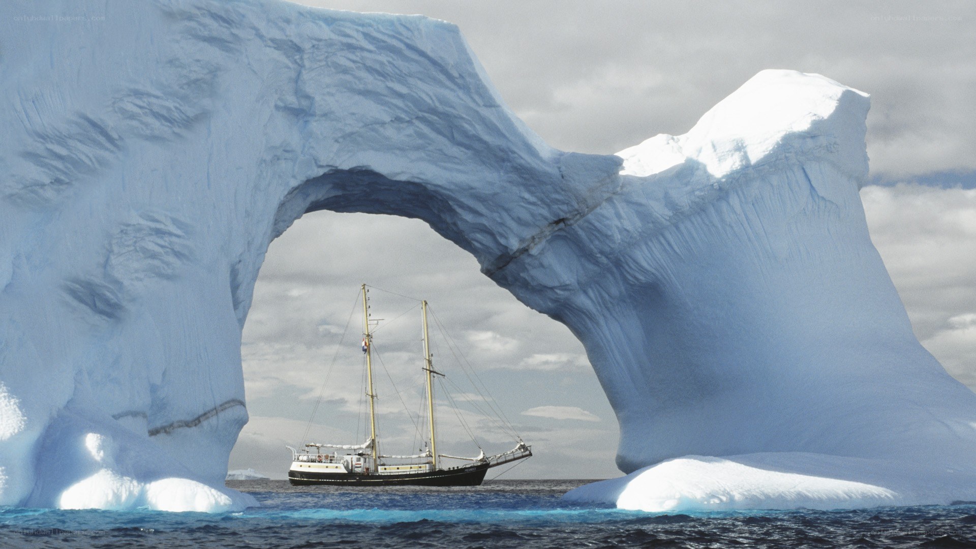 Sailing under an iceberg arch