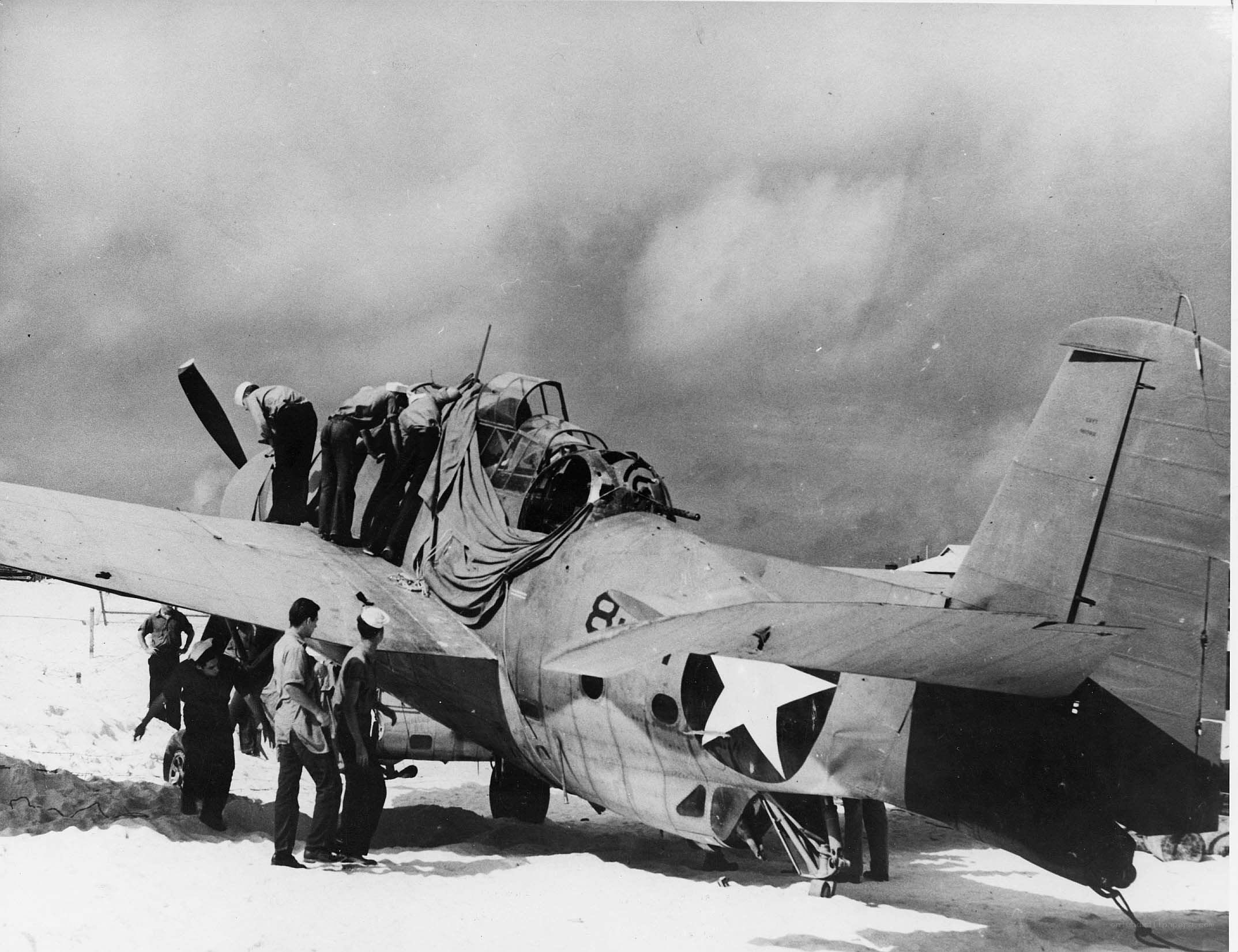 Sailors inspecting damaged aircraft