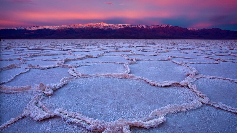 Salt flats at sunset with mountains