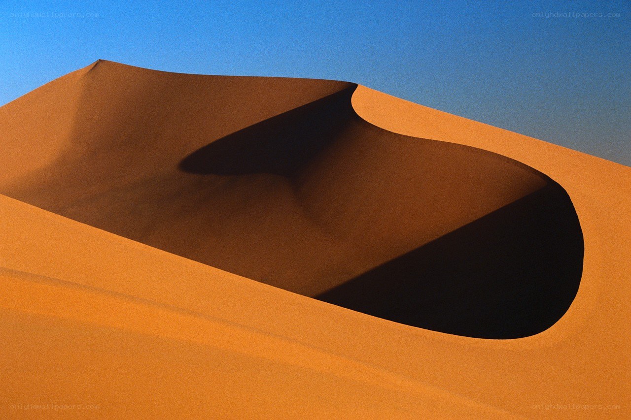 Sand dune under blue sky