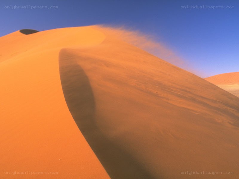 Sand dune under blue sky