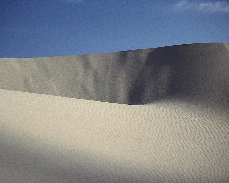 Sand dunes under blue sky