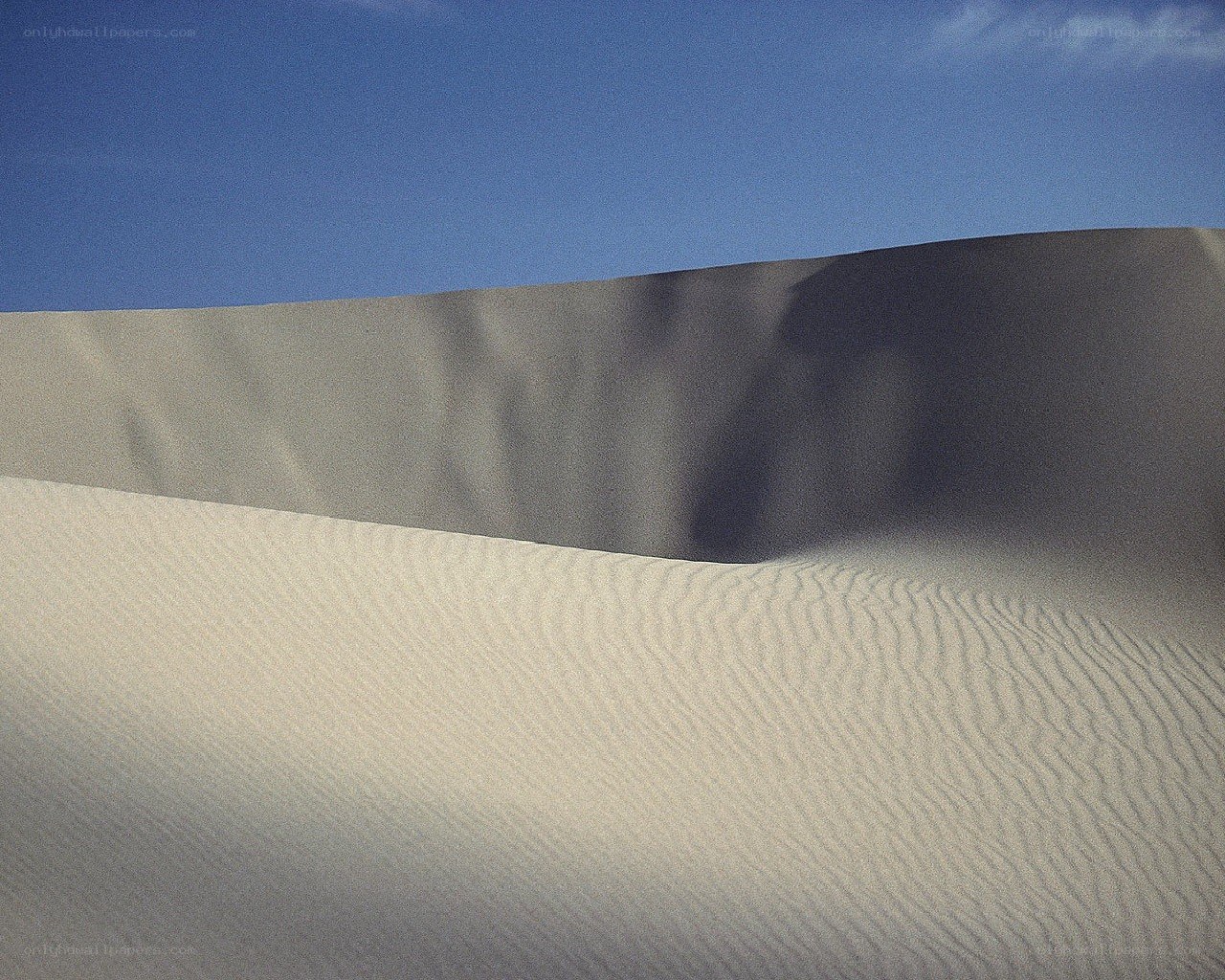 Sand dunes under blue sky