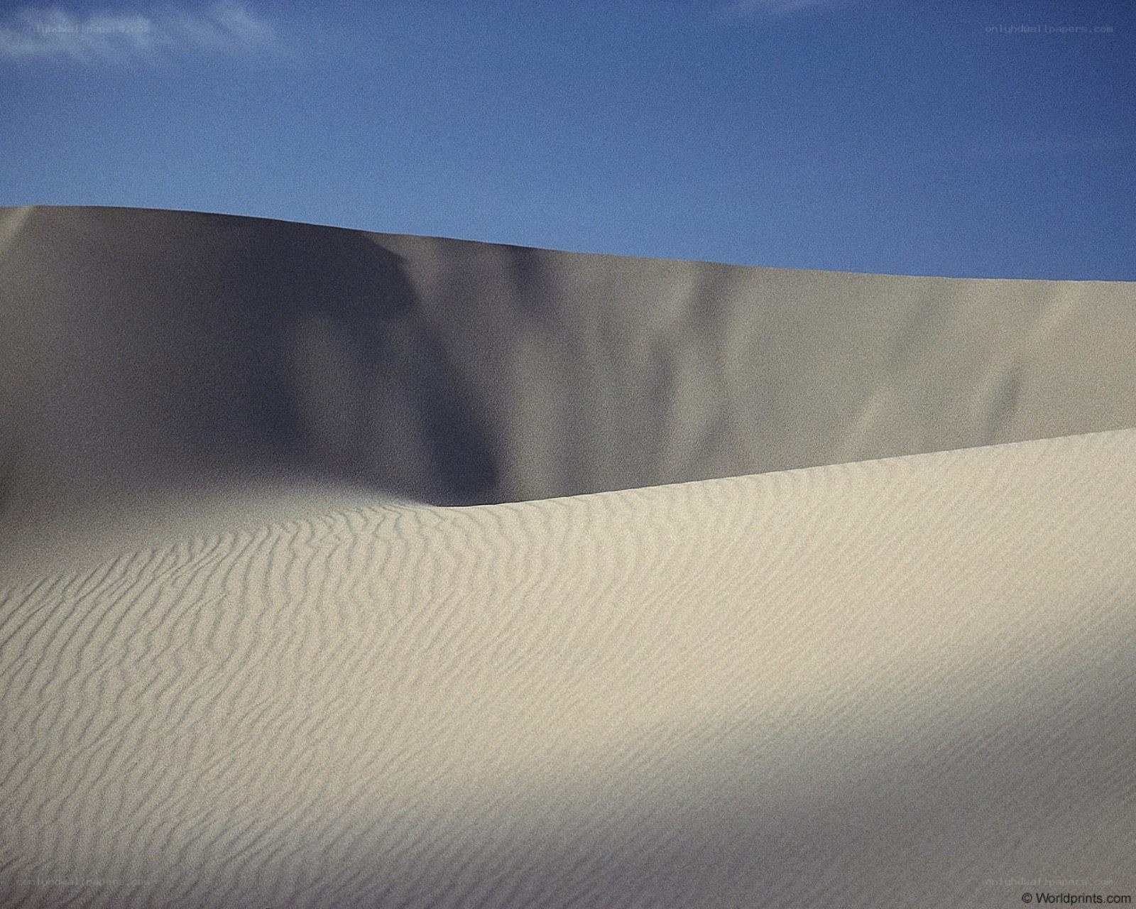 Sand dunes under blue sky