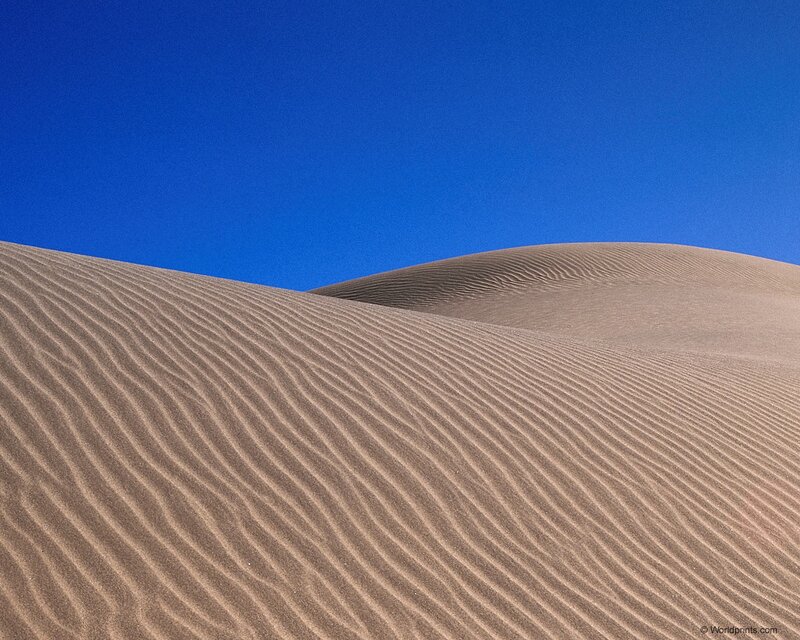 Sand dunes under blue sky