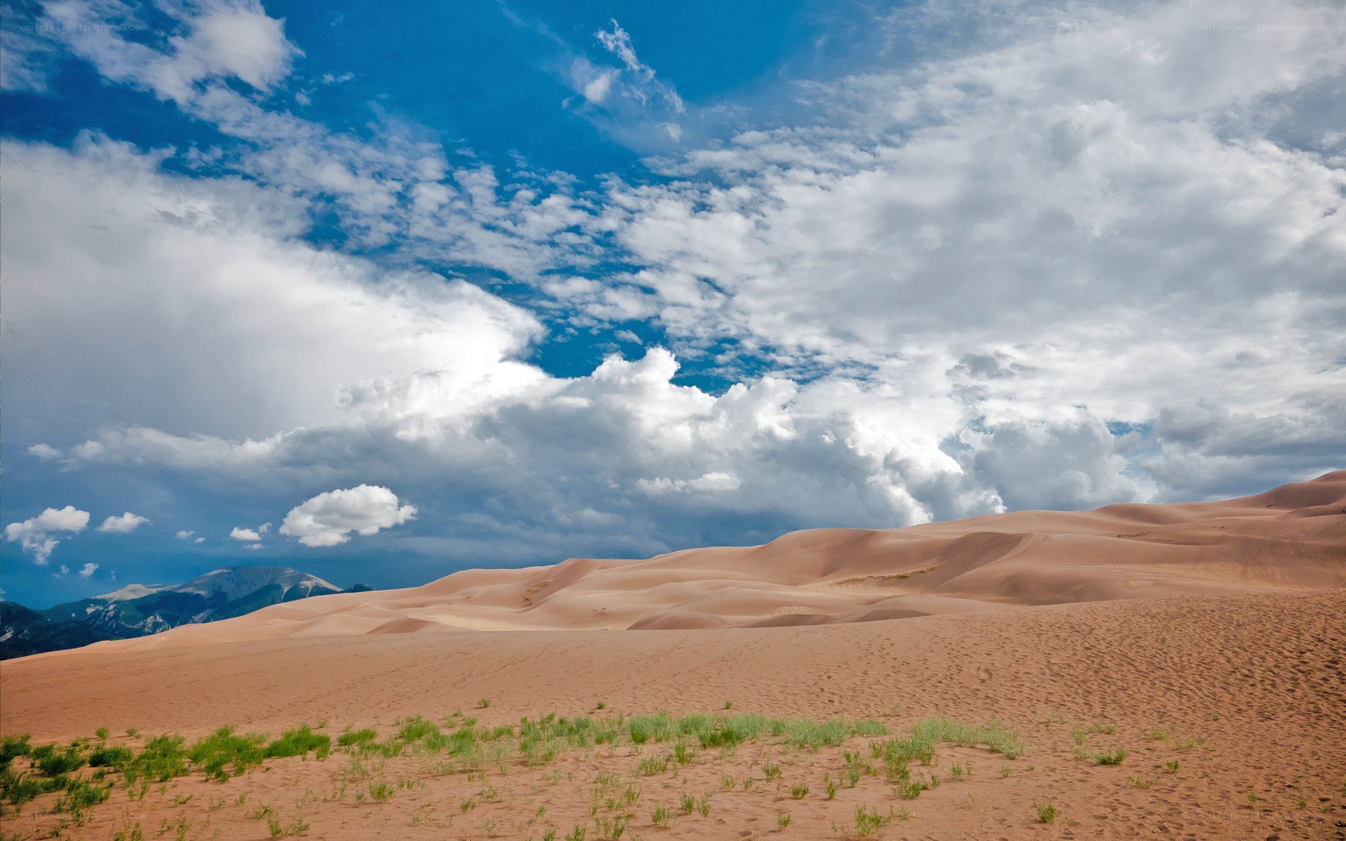 Sand dunes under cloudy sky