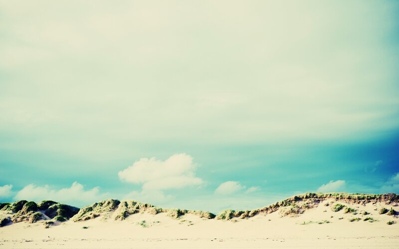 sand dunes under cloudy sky
