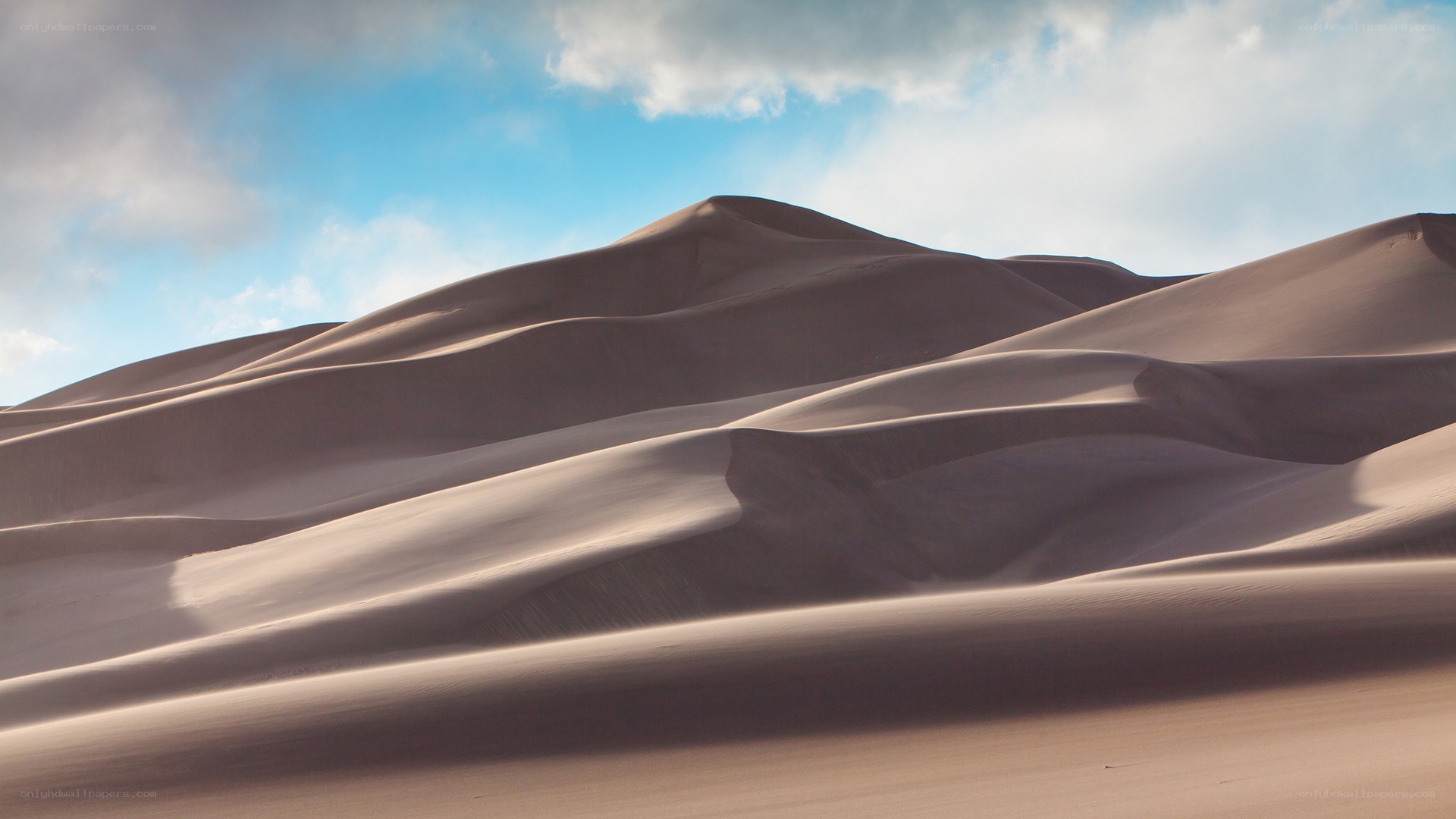 Sand dunes under cloudy sky