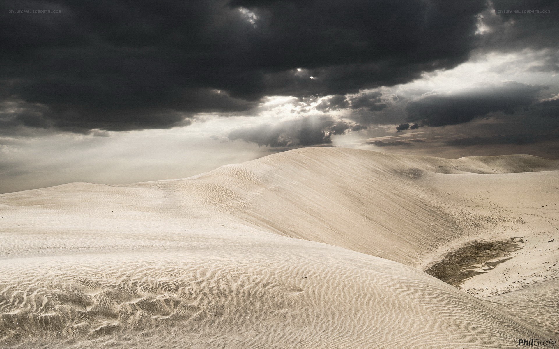 Sand dunes under stormy sky