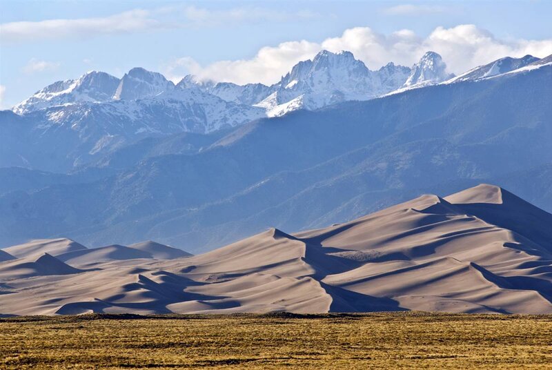 sand dunes with snow-capped mountains