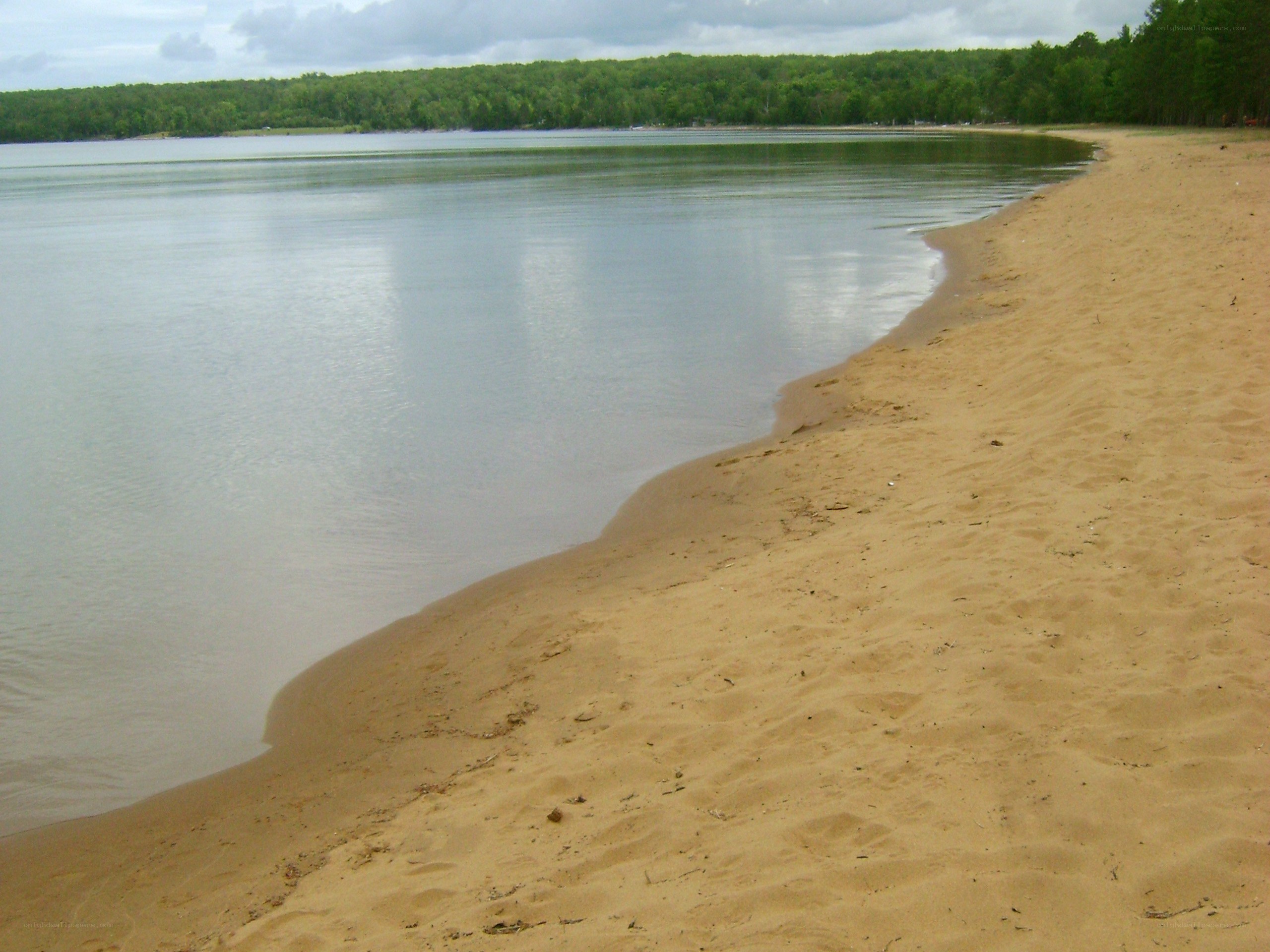 sandy beach along a calm lake