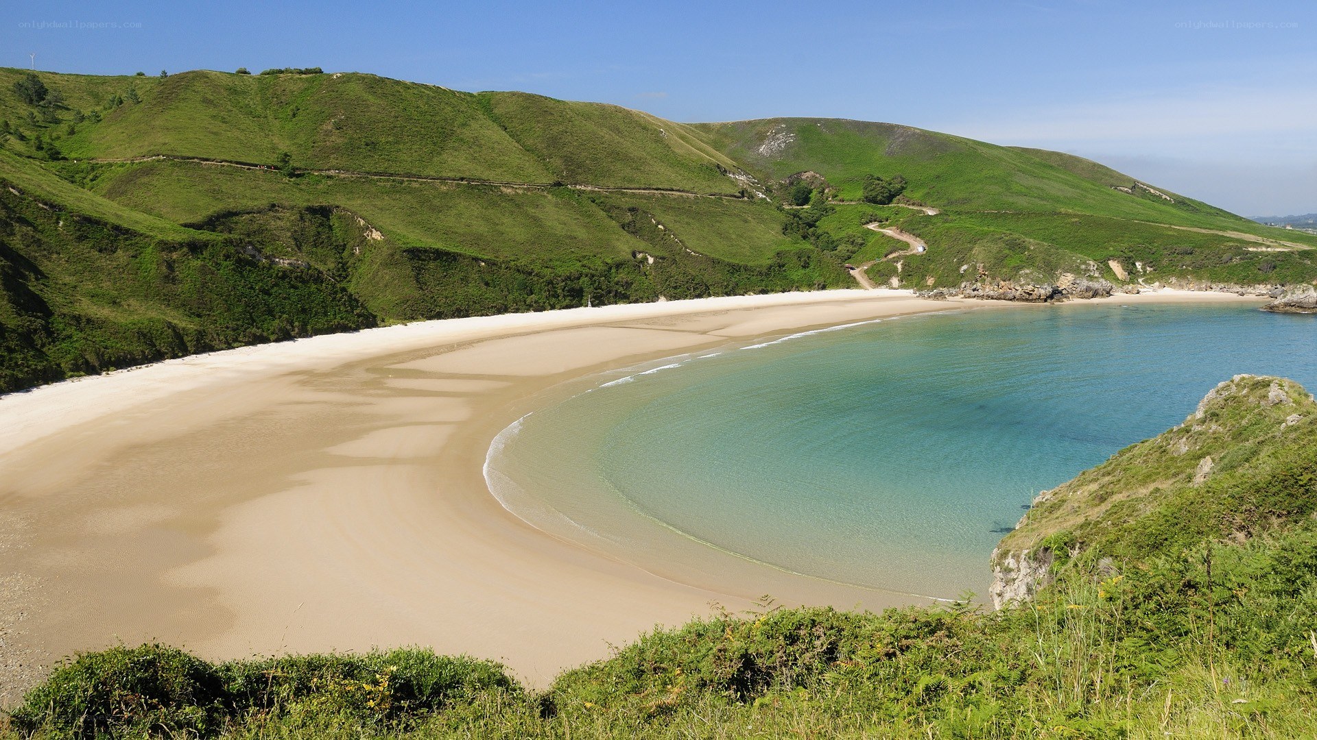 sandy beach cove with green hills