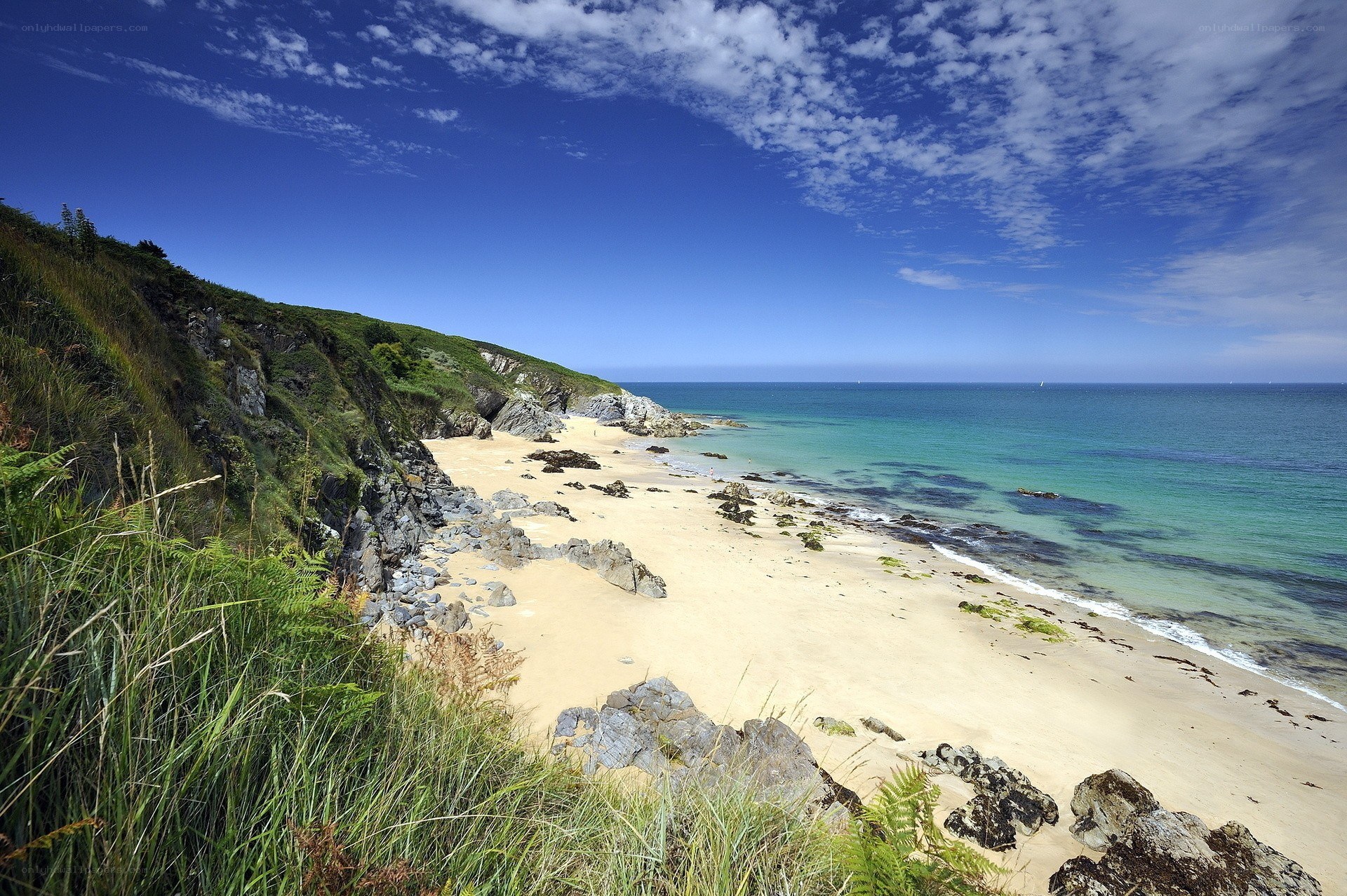 sandy beach with cliffs and blue sea