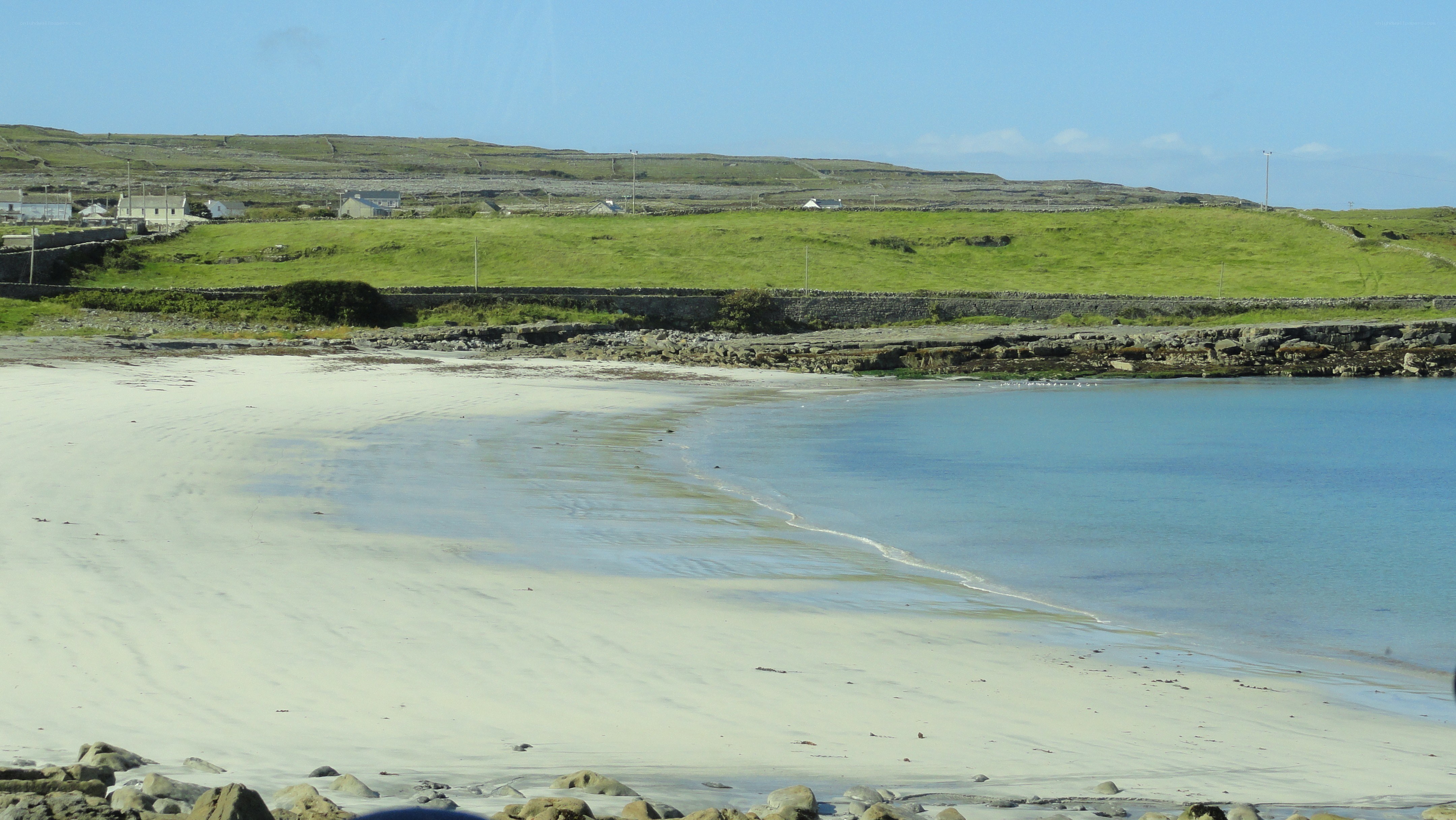 sandy beach with green hills