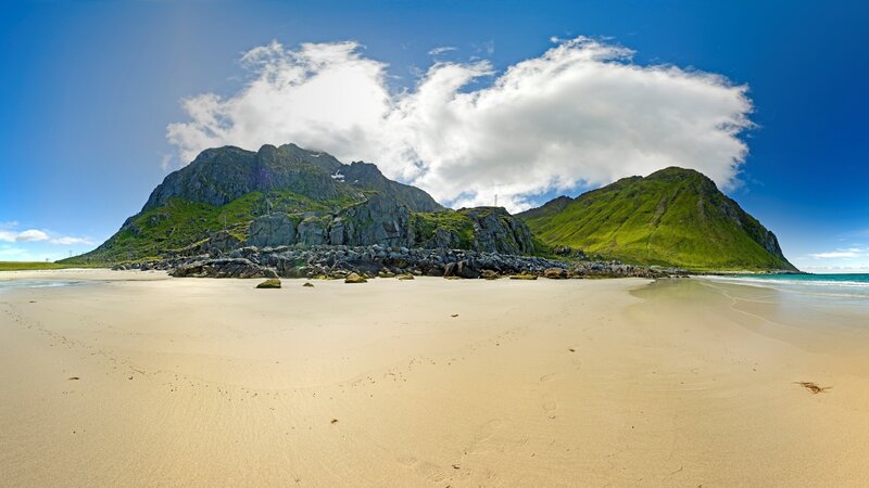 sandy beach with green mountains