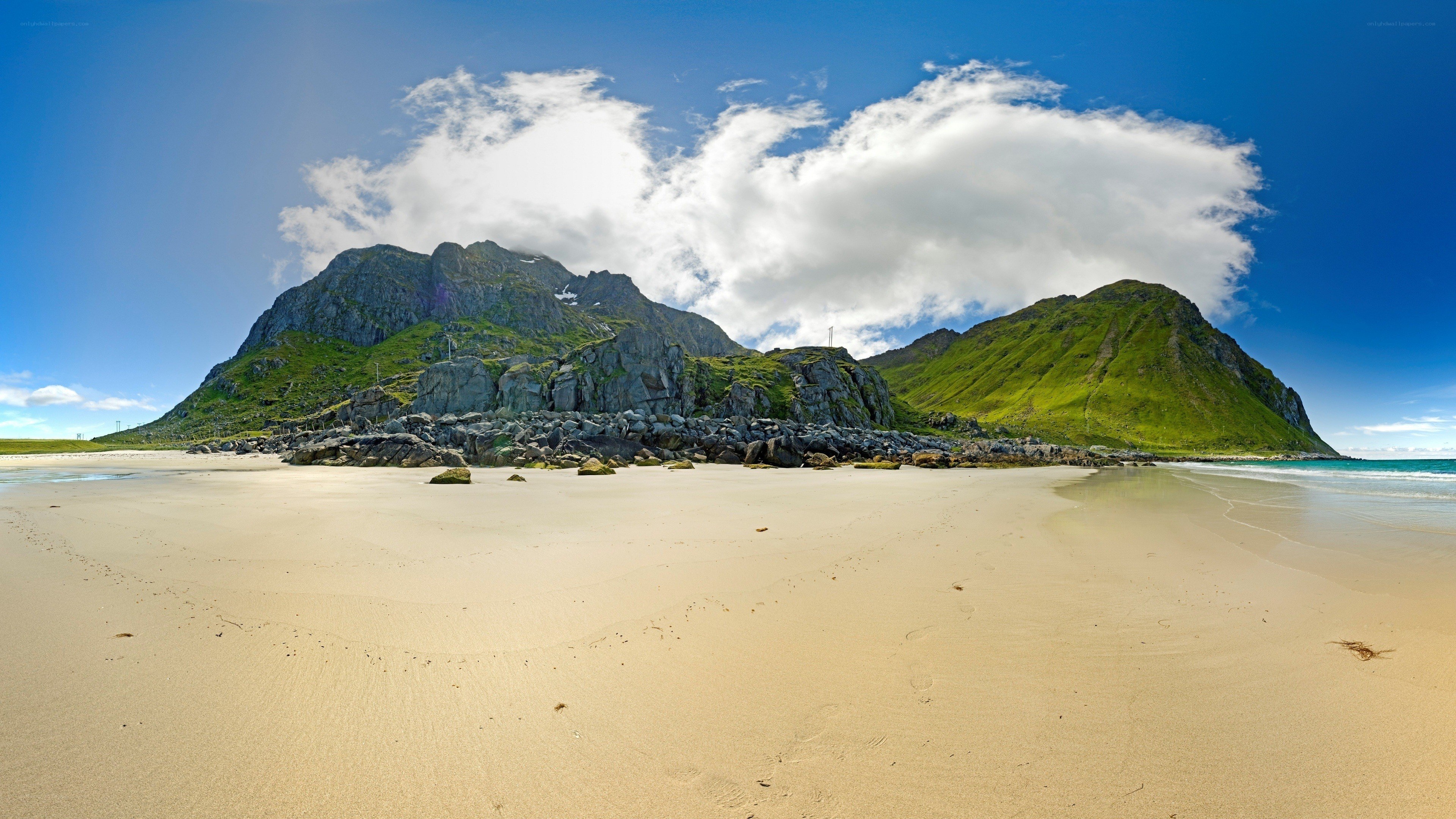 sandy beach with green mountains