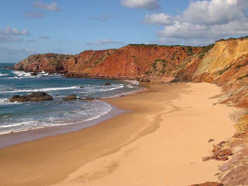 sandy beach with red cliffs