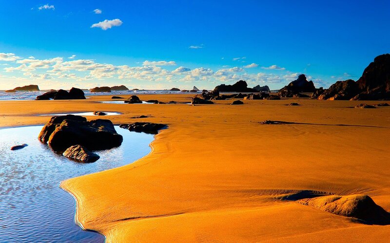 sandy beach with rocks and ocean