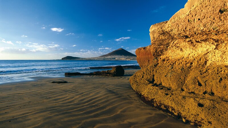 sandy beach with volcanic rock