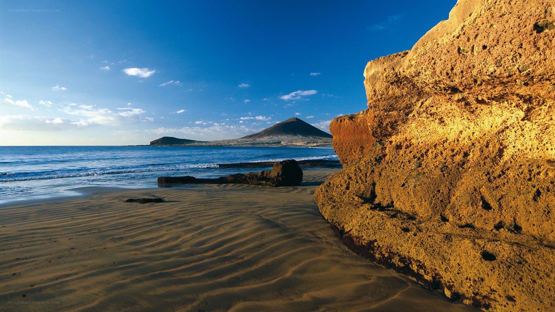 sandy beach with volcanic rock