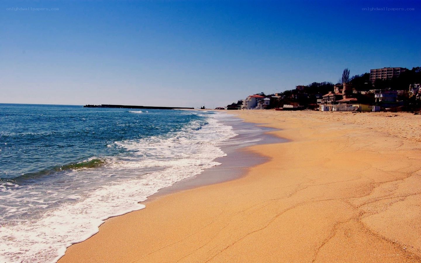 Sandy beach with waves and buildings