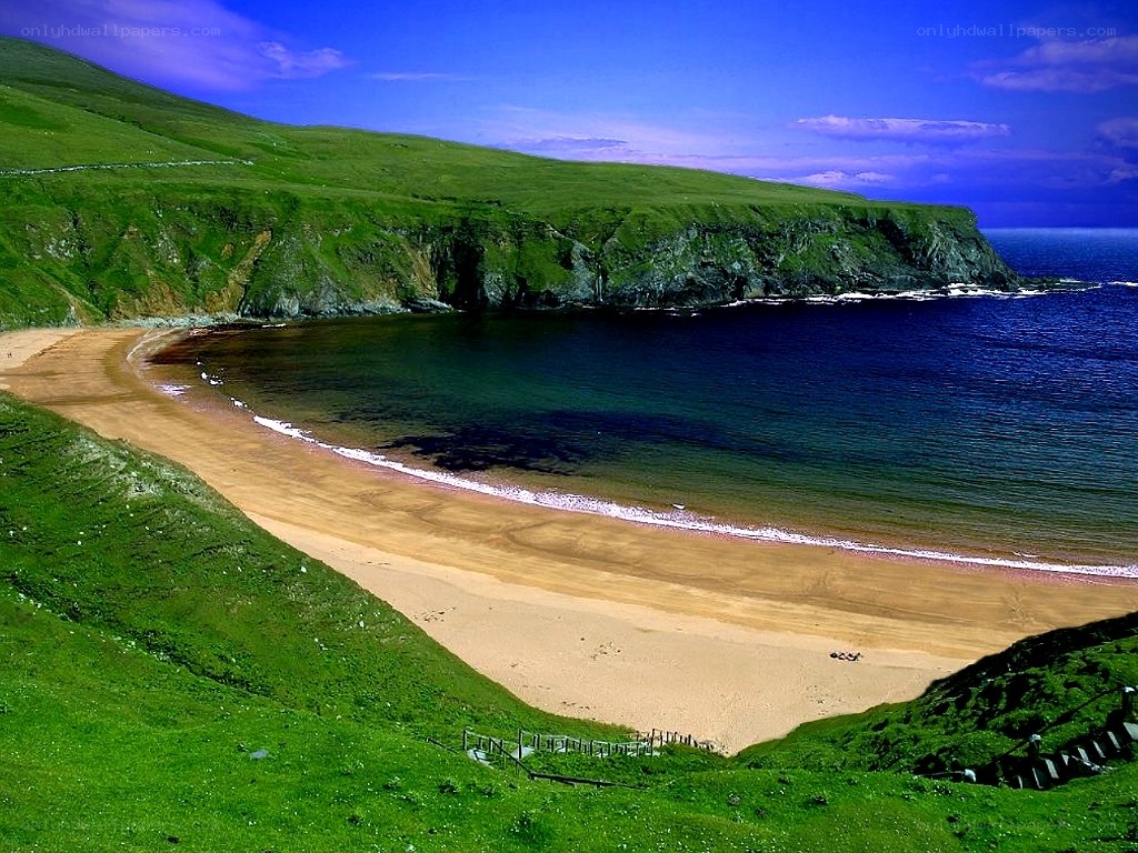 sandy cove with green cliffs