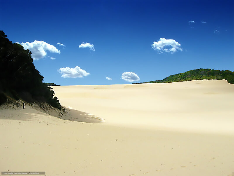 Sandy dunes under blue sky