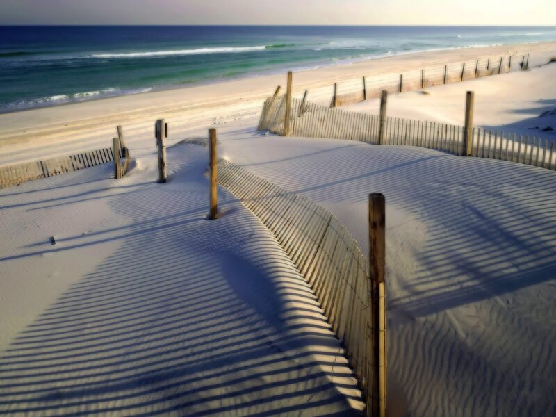 sandy dunes with wooden fence