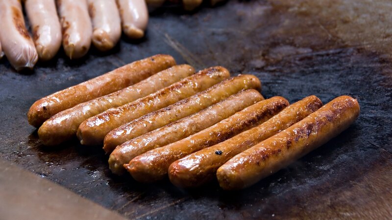 Sausages grilling on a hot surface
