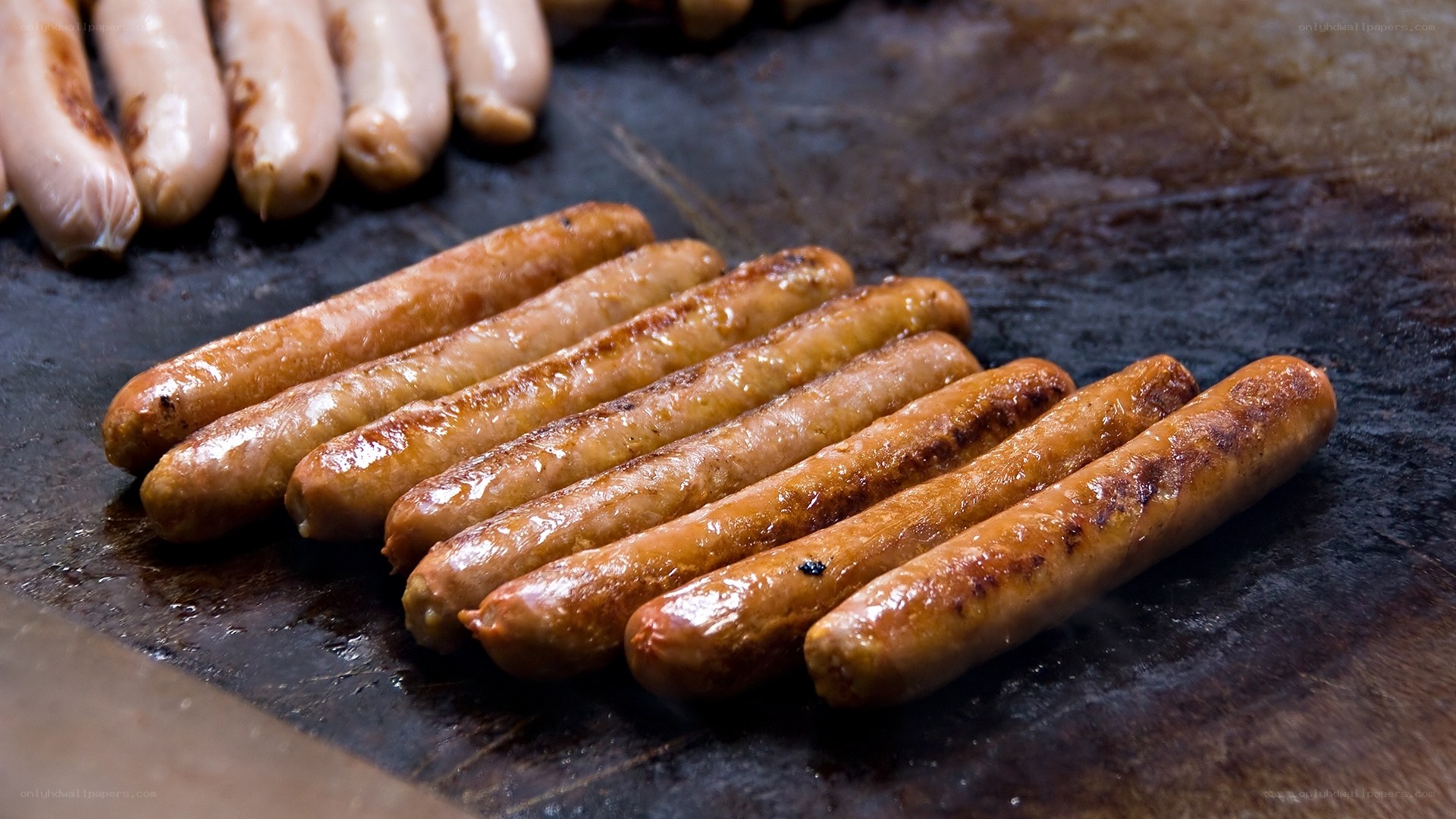 Sausages grilling on a hot surface
