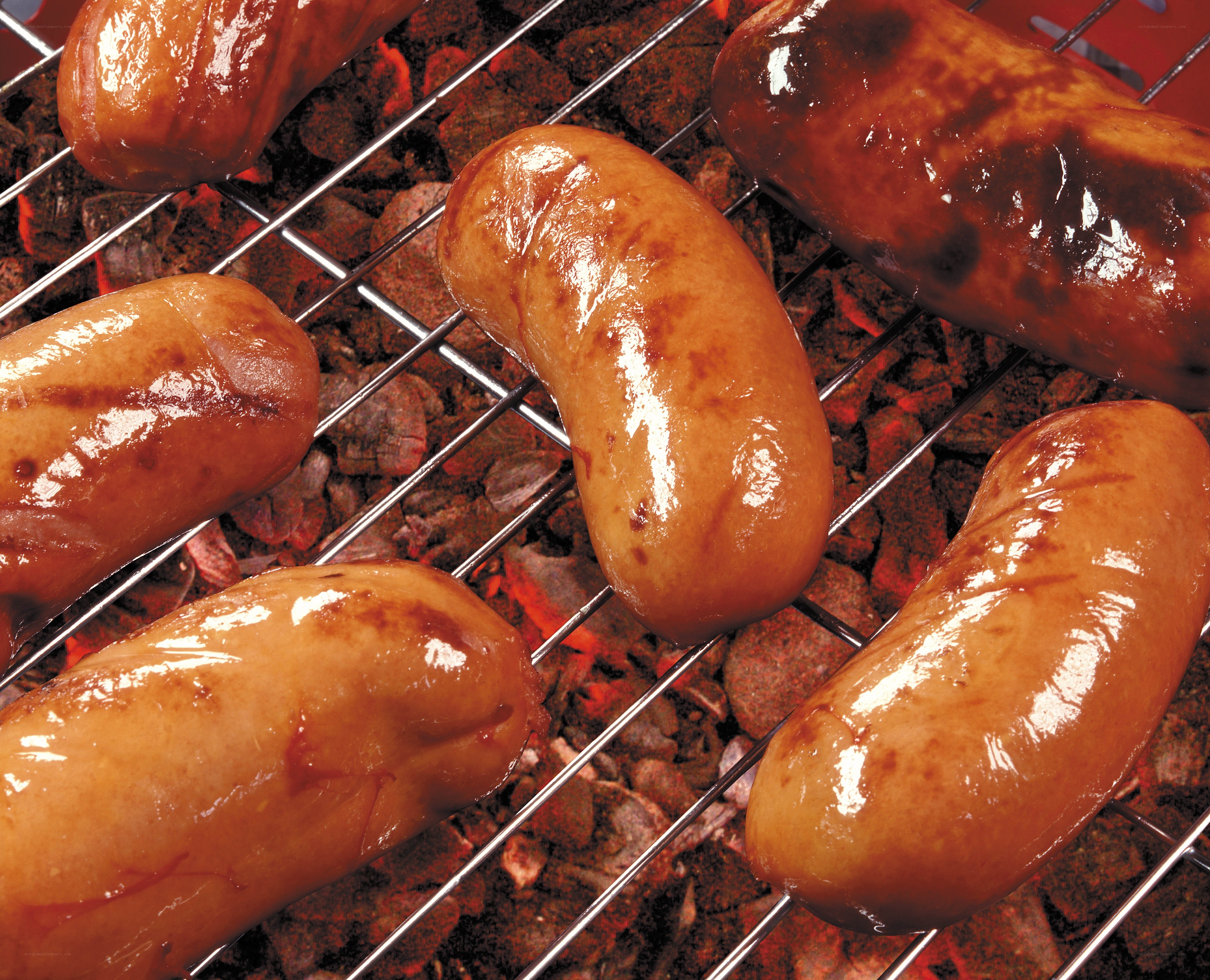 sausages grilling on charcoal