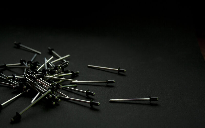 scattered rivets on black surface