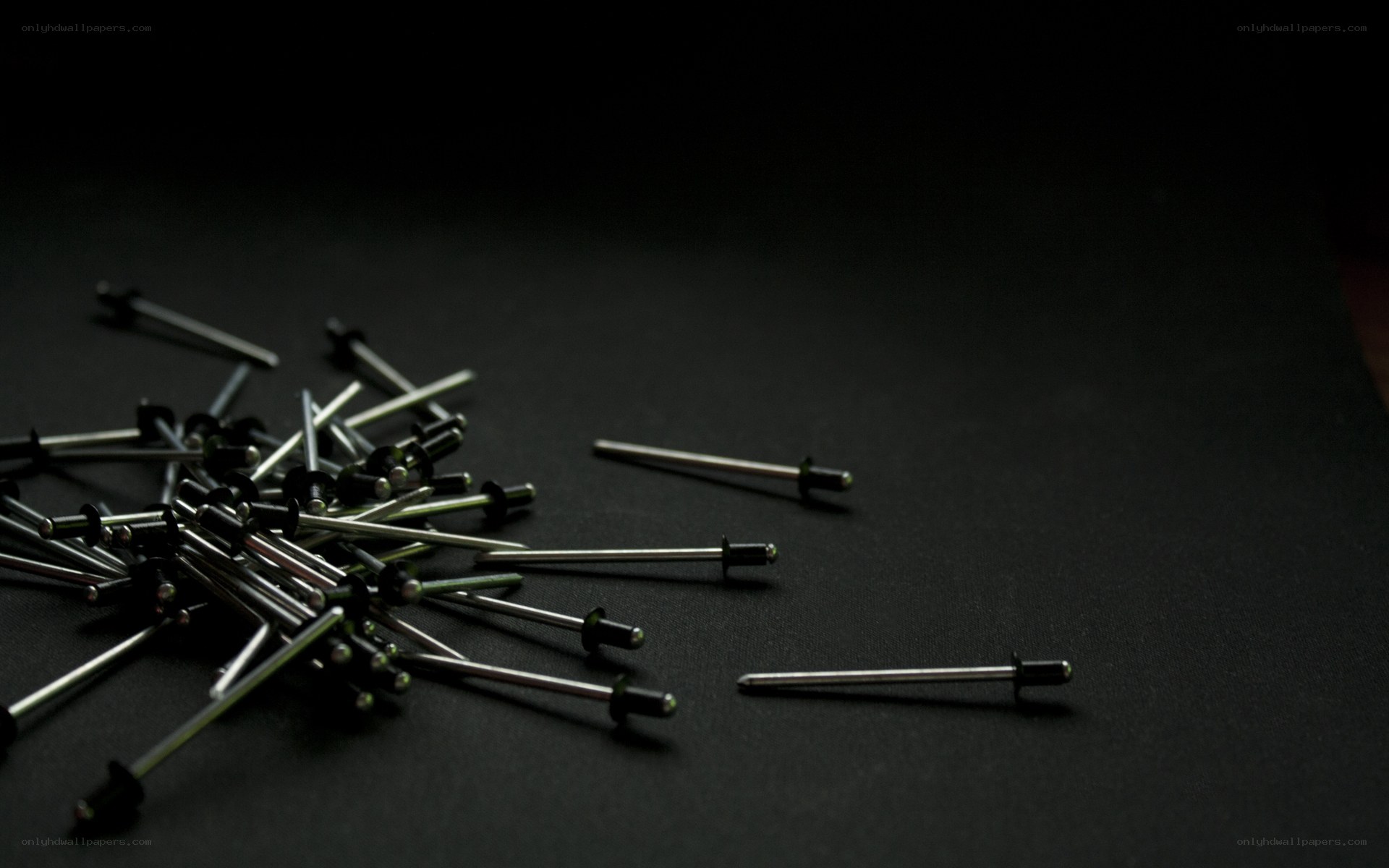 scattered rivets on black surface