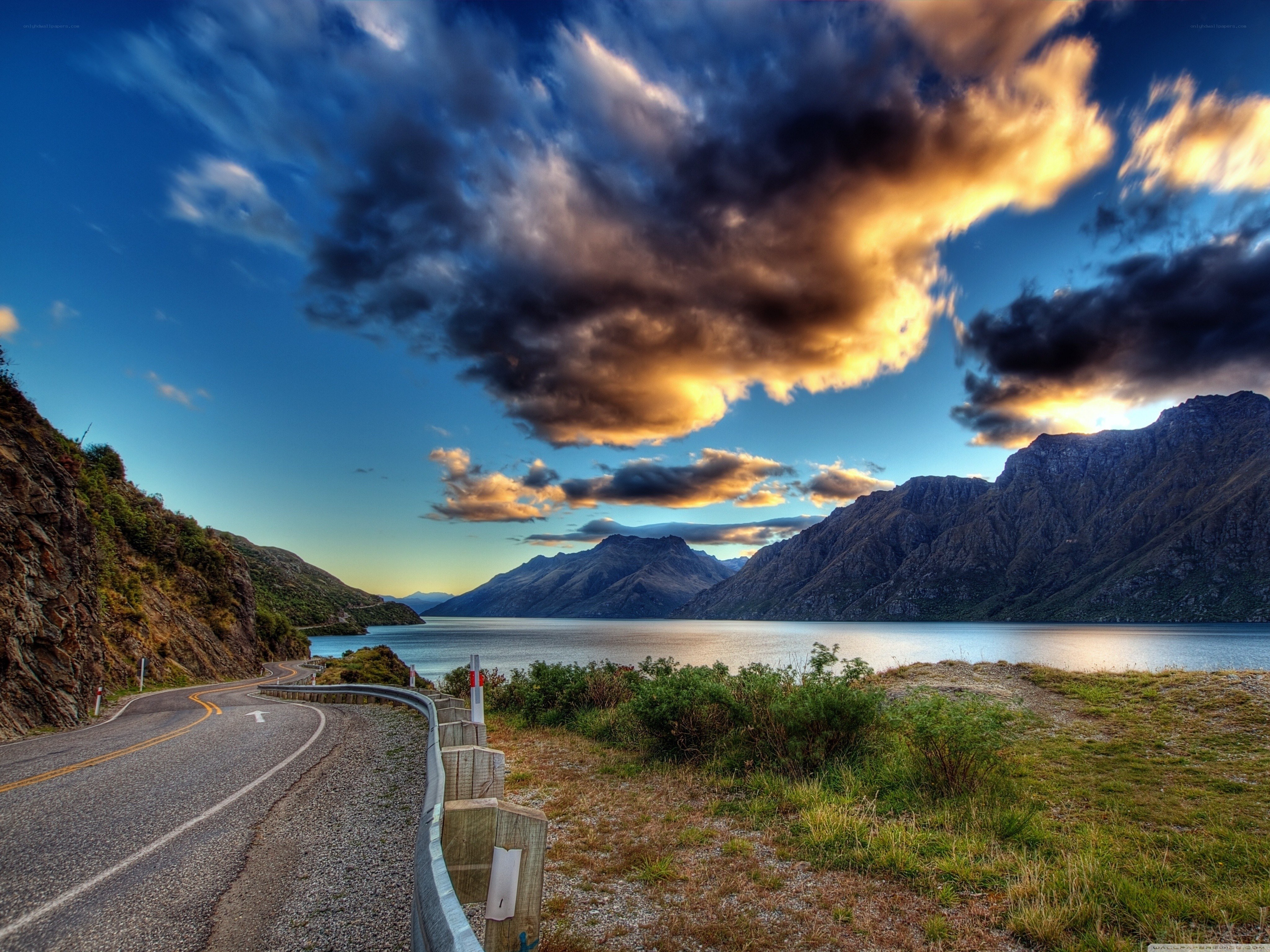 scenic road by lake at sunset