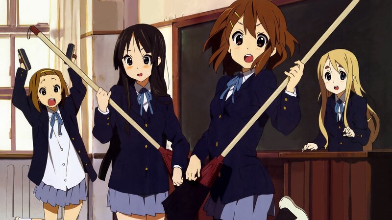 Schoolgirls with brooms in classroom