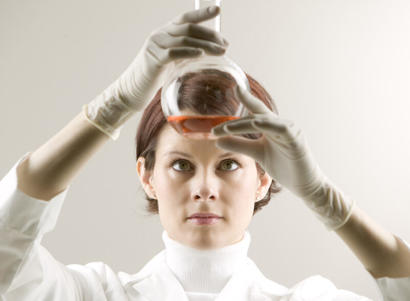 scientist examining liquid in flask