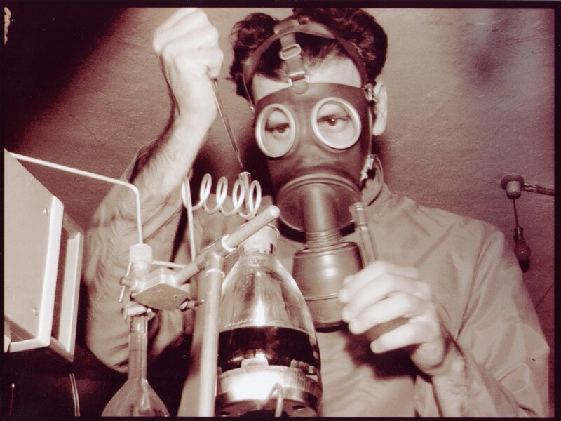Scientist in gas mask with lab equipment