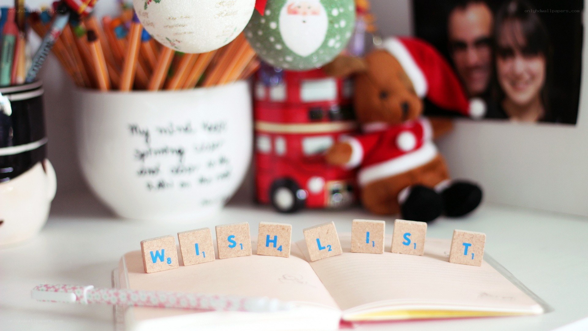Scrabble tiles spell 'WISHLIST' on a notebook