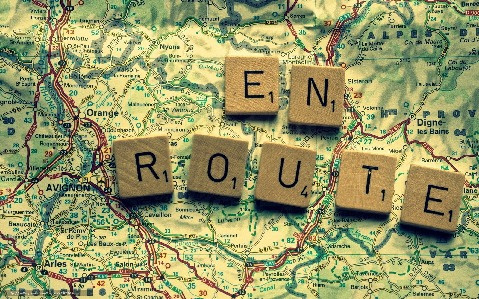 Scrabble tiles spelling ROUTE on a map