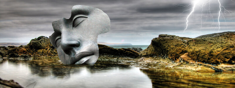 Sculpted face on stormy shore