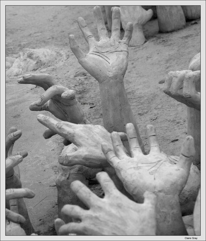 Sculpted hands emerging from sand