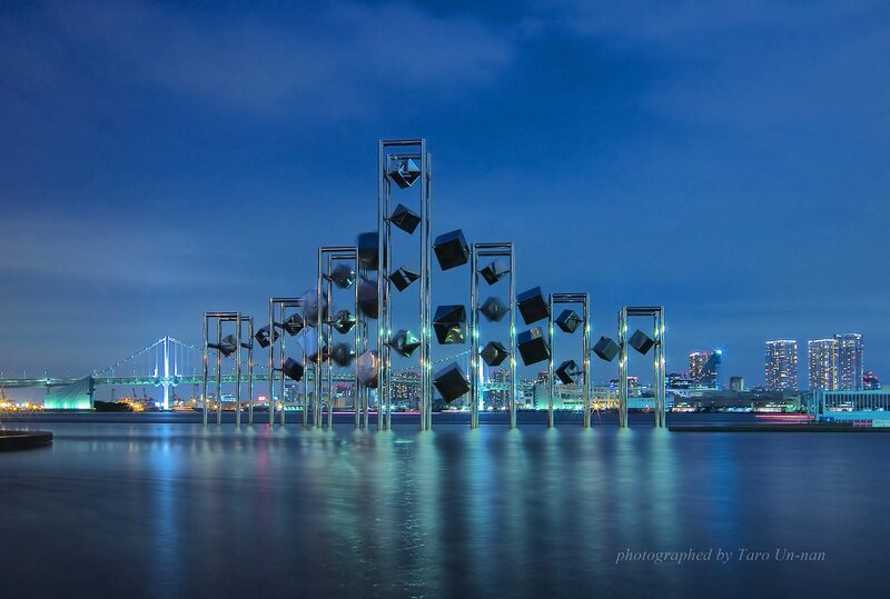 sculpture at dusk with city skyline