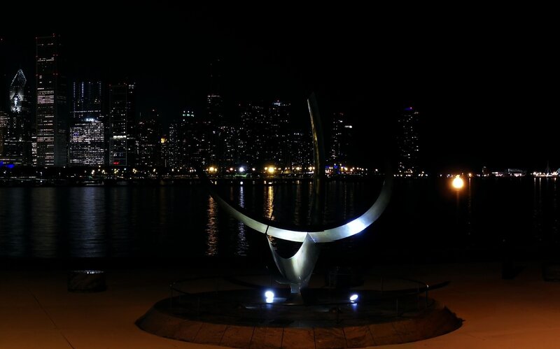 Sculpture at night with city skyline