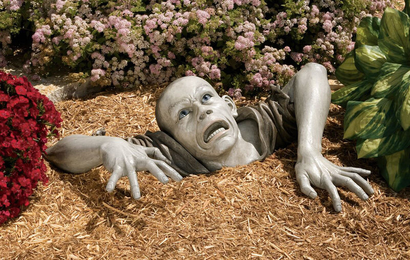 sculpture of man emerging from ground