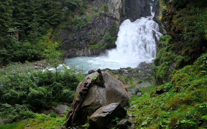 Sculpture on Rock by Waterfall