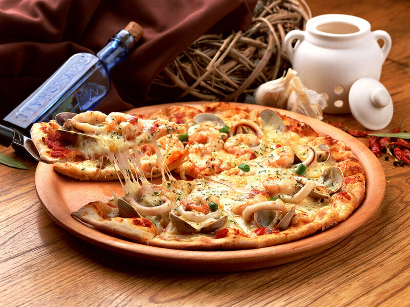 Seafood pizza on wooden plate
