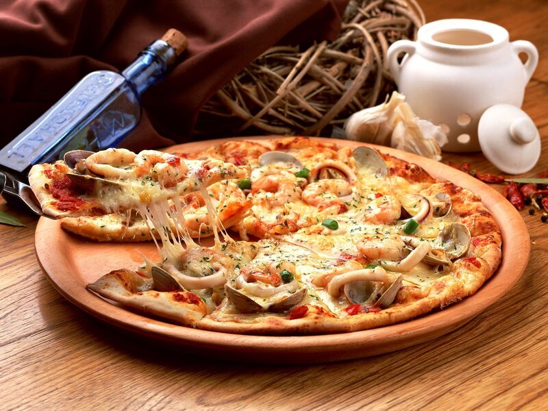 Seafood pizza on wooden plate