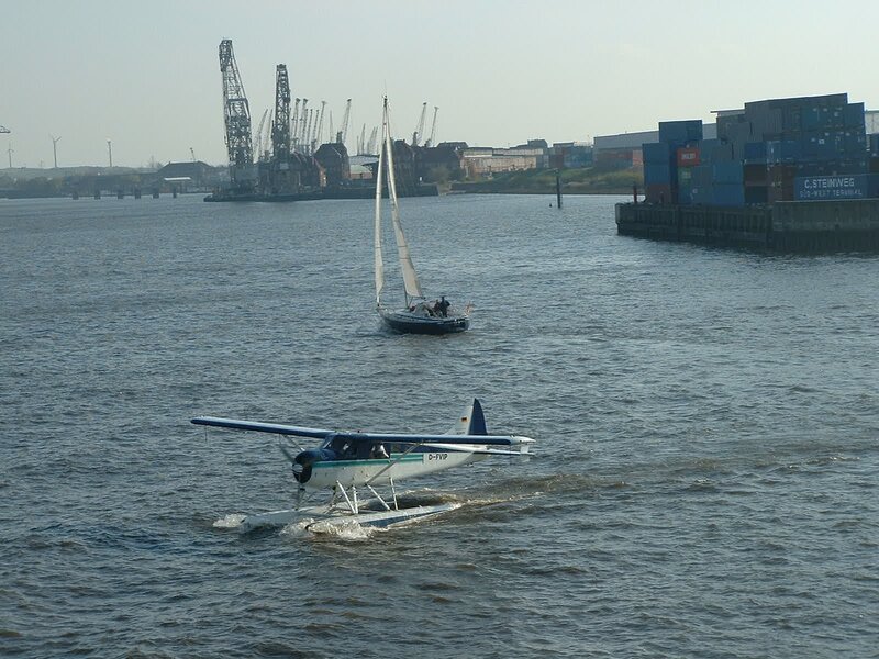 Seaplane and sailboat on a river